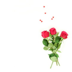 Obraz premium Tło kompozycji Walentynki. Bukiet pięknych czerwonych róż i czerwonych serc na białym tle. widok z góry. Skopiuj miejsce