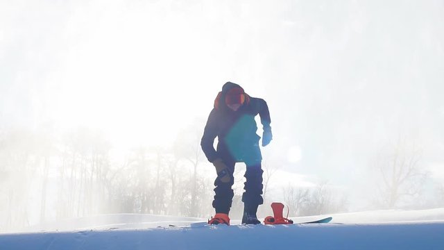 Snowboarder put on snowboard boots beffore the competition. preparation.