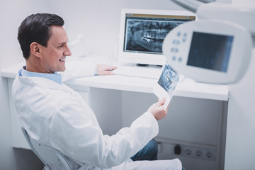Pleased brunette male person wearing medical uniform