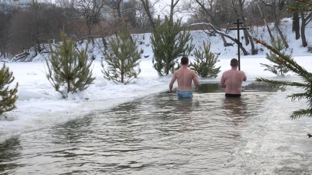 diving into the hole in baptism. Orthodox holiday baptism. people dive in cold water in winter