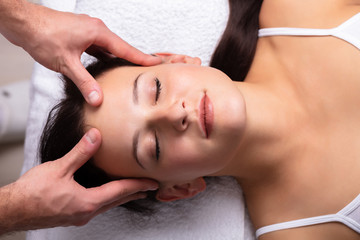 Fototapeta na wymiar Therapist Massaging Woman's Head