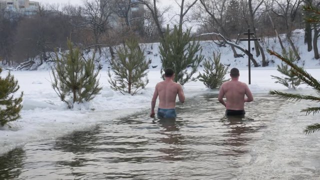 diving into the hole in baptism. Orthodox holiday baptism. people dive in cold water in winter