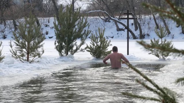 diving into the hole in baptism. Orthodox holiday baptism. people dive in cold water in winter