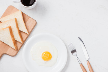 Fried eggs with toasts and coffee on the table