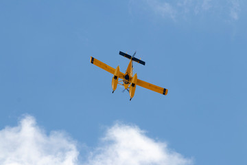 Fototapeta na wymiar Hidroavión volando por debajo de las nubes