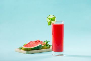 slice of watermelon for smoothies with lime on blue background