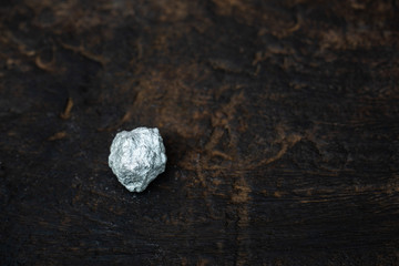 lump of silver or platinum on dark wood background