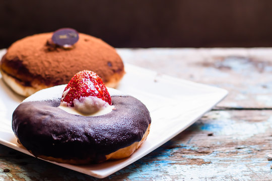 Chocolate donut with strawberry with blue painted wooden table  background