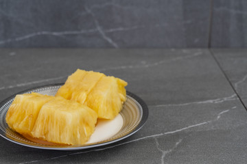 Pieces of pineapple on stone background.