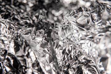 Silver foil closeup texture. Black and white abstract background. Foil crumpled.