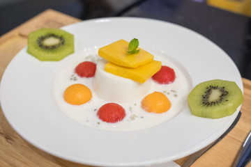 Panna Cotta with Watermelon, Melon, Mango and Kiwi served on plate