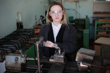 Young woman engineer working at machine tool