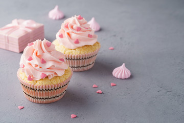 Valentine cupcakes decorated with sweet hearts and a gift box.