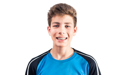 Young boy smiles genuinely on a white background. Braces are installed on the teeth of the boy © Мар'ян Філь