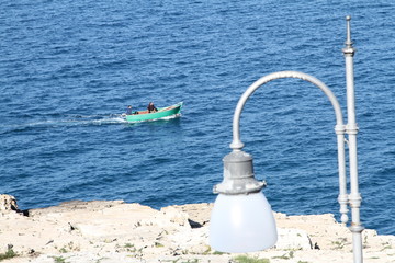 barchetta a motore corre per mare vicino alla costa
