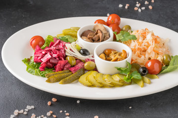 Pickled vegetables in a white plate on gray background