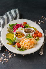 Pickled vegetables in a white plate on gray background