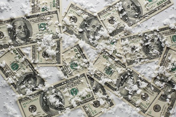 Top view of 100 dollars banknotes on white background. On top of the dollars is snow. - 244167174