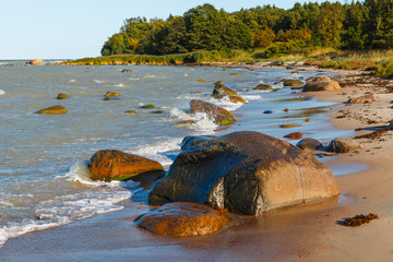 Sandy lagoon on rocky sea shore on sunny summer day . Idyllic seascape.