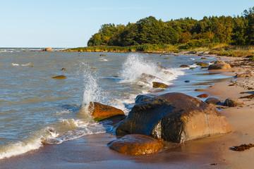 Sandy lagoon on rocky sea shore on sunny summer day . Idyllic seascape.