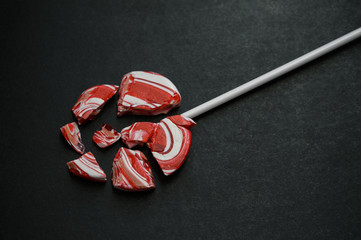 Broken lollipop on a dark background.