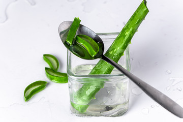 on white background isolated aloe vera leaves and freshly cut leaf slices