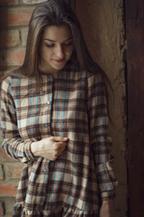 Portrait of a sexual young woman wearing checkered dress. Beautiful smart girl. Beauty, fashion of women wear showroom