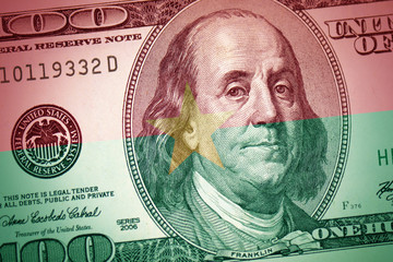 Obraz na płótnie Canvas flag of burkina faso on a american dollar money background