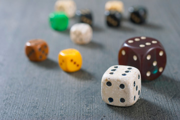 used dices with six dots on aged wooden background