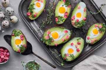 Keto diet dish: Avocado boats with ham cubes, quail eggs and cress sprout