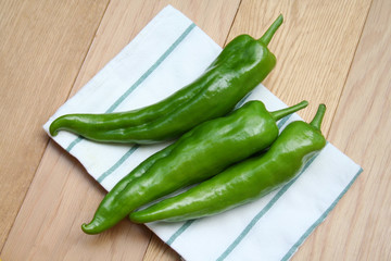 Fresh long green peppers on wooden table. Summer vegetables