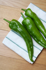 Fresh long green peppers on wooden table. Summer vegetables