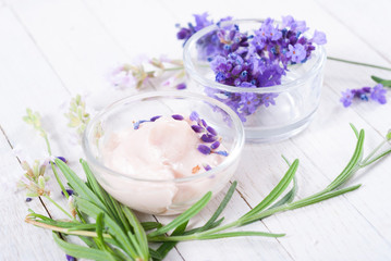 cosmetic cream and lavender flowers on white wood table background