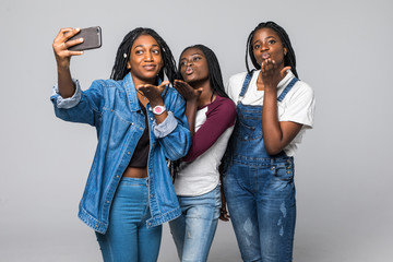 Young african women blow kiss on selfie photo from phone isolated on white background