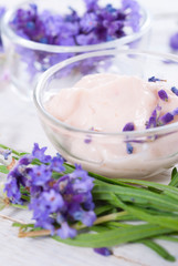 cosmetic cream and lavender flowers on white wood table background