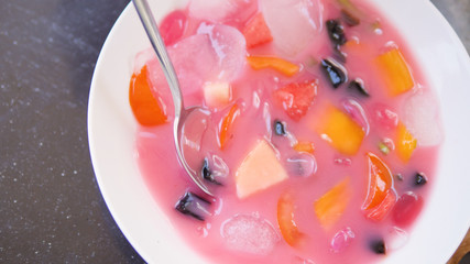 cold fruit soup with slices of tropical fruit and ice. Traditional Asian Indonesian fruit soup dessert.