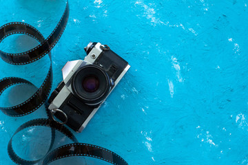 Retro film camera with roll of film on blue background with space for text, Pastel Sweet Style. Flat lay top view
