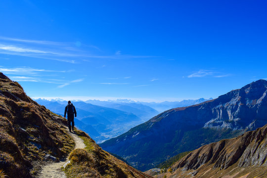 Hiker in the region of Torrenthorn, with a stunning view of the swiss alps, Switzerland/Europe