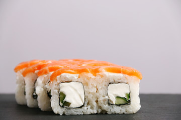 philadelphia roll on slate. roll with salmon and light background