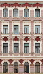 The facade of a historic building. Burgundy bas-reliefs on the Windows