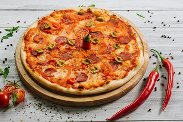 Pizza Pepperoni with mozzarella, salami, pepper and olives on the white wooden background