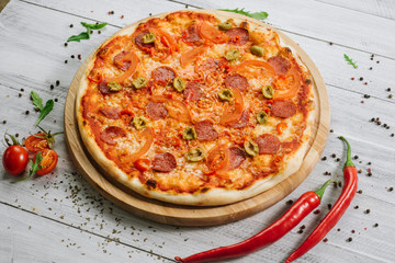 Pizza Pepperoni with mozzarella, salami, pepper and olives on the white wooden background