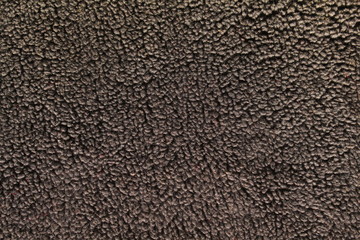 Fototapeta premium Textured background of dark brown sheepskin.