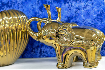 Gilded figurine of an elephant with a raised trunk up.