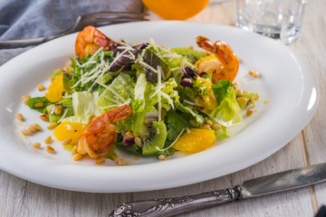 Salad with shrimps, green leaves and pine nuts