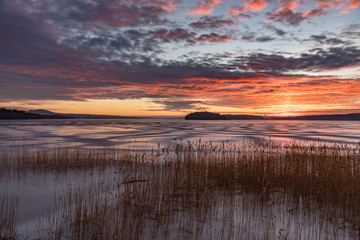 Orange sunset over frozen lake in Sweden