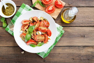 Tomato salad with basil,mozzarella cheese and pesto sauce .
