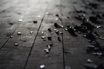 Small shards of glass on the dark wooden floor