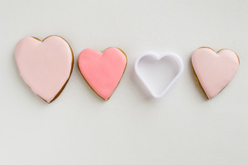 Pink colored gingerbread and honey cakes cookies . In the shape of a heart. On a light wooden background. Frame. Frame. Place for text. The concept of love, mother's day, cooking, St. Valentine.