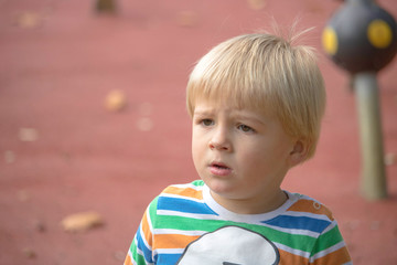 little blond boy portrait in the park